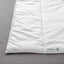 Close-up of the SÄFFEROT duvet's smooth, quilted white surface on a grey bedsheet